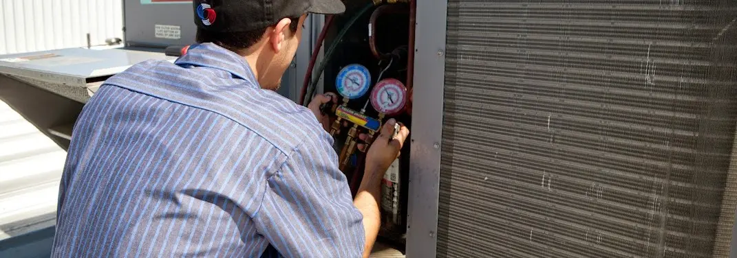 HVAC technician servicing a condenser unit in Lackawaxen
